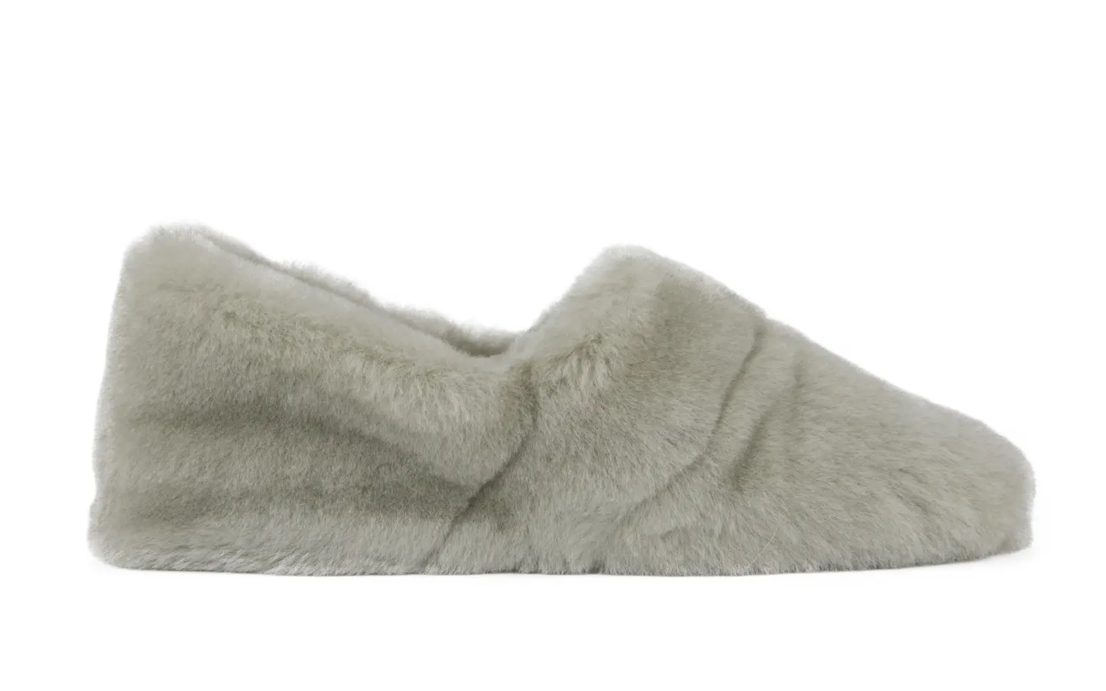 TESSA Lammfell in Paloma, elegant und bequem, seitlich auf einem hellen Untergrund platziert, zeigt die weiche Oberfläche und das stilvolle Design.