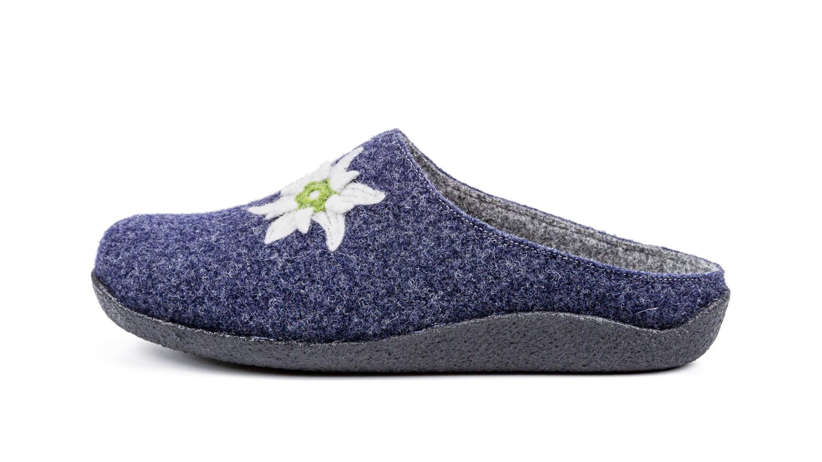 Der Schuh VRONI aus Filz in Jeansblau mit Edelweiß-Applikation, seitlich auf einem neutralen Hintergrund positioniert.