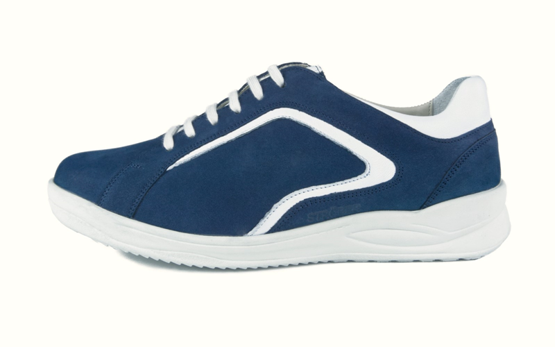 Der KAYA Nubuk+LammNappa Schuh in marine und weiß liegt auf einem hellen Untergrund und zeigt seine elegante Form und hochwertige Verarbeitung.