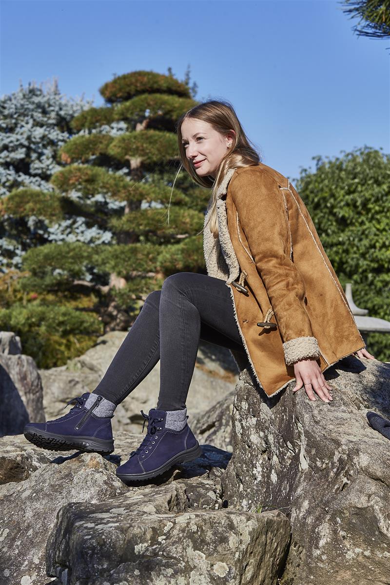 Der Schuh RONJA in blau aus NubukFilz mit Wollfutter, in seitlicher Ansicht auf einem neutralen Hintergrund platziert.