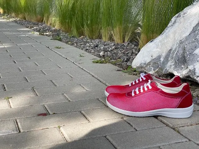 Rote Mesh Nubuk Schuhe namens MERLE, seitlich auf einem neutralen Hintergrund platziert.